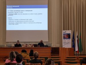 Usposabljanje v teku, v ospreju projekcijsko platno in predavatelja Andreja Bevc in Tilen Škraba.