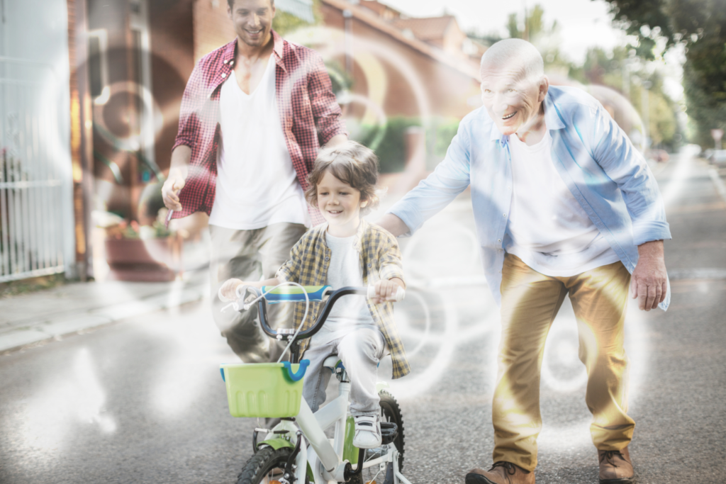 Otrok se vozi s kolesom, slika je zamegljena in prekrita s svetlimi madeži (simulacija sive mrene).