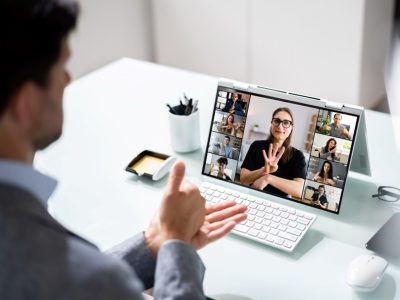 Dve osebi med videokonferenco komunicirata v znakovnem jeziku, ostali udeleženci spremljajo pogovor.