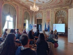 Udeleženci spremljajo predavanje o digitalni dostopnosti v razstavni dvorani Muzeja novejše in sodobne zgodovine Slovenije.