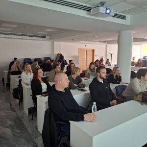 Udeleženci osnovnega usposabljanja o digitalni dostopnosti v Ljubljani spremljajo predavanje v sodobni predavalnici.