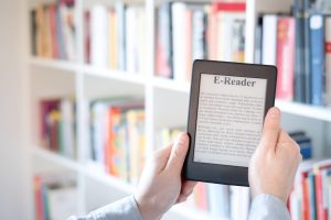 Una persona utilizza un e-reader per leggere un libro.