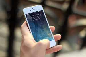 Una persona tiene in mano uno smartphone con lo schermo bloccato.